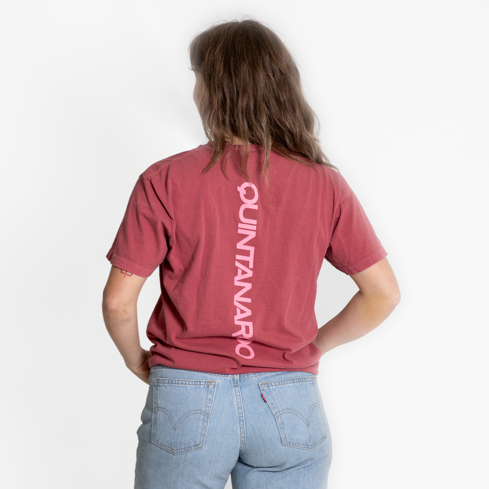 Person wearing a red t-shirt with 'Quintanaroo' printed on the back, standing against a white background.