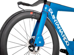 A close up of a blue QR bike's wheel on a white background