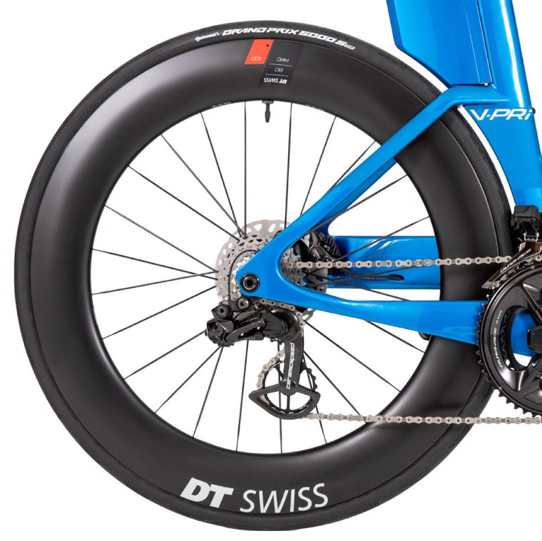 Um close up da roda preta de uma bicicleta QR azul em um fundo branco.