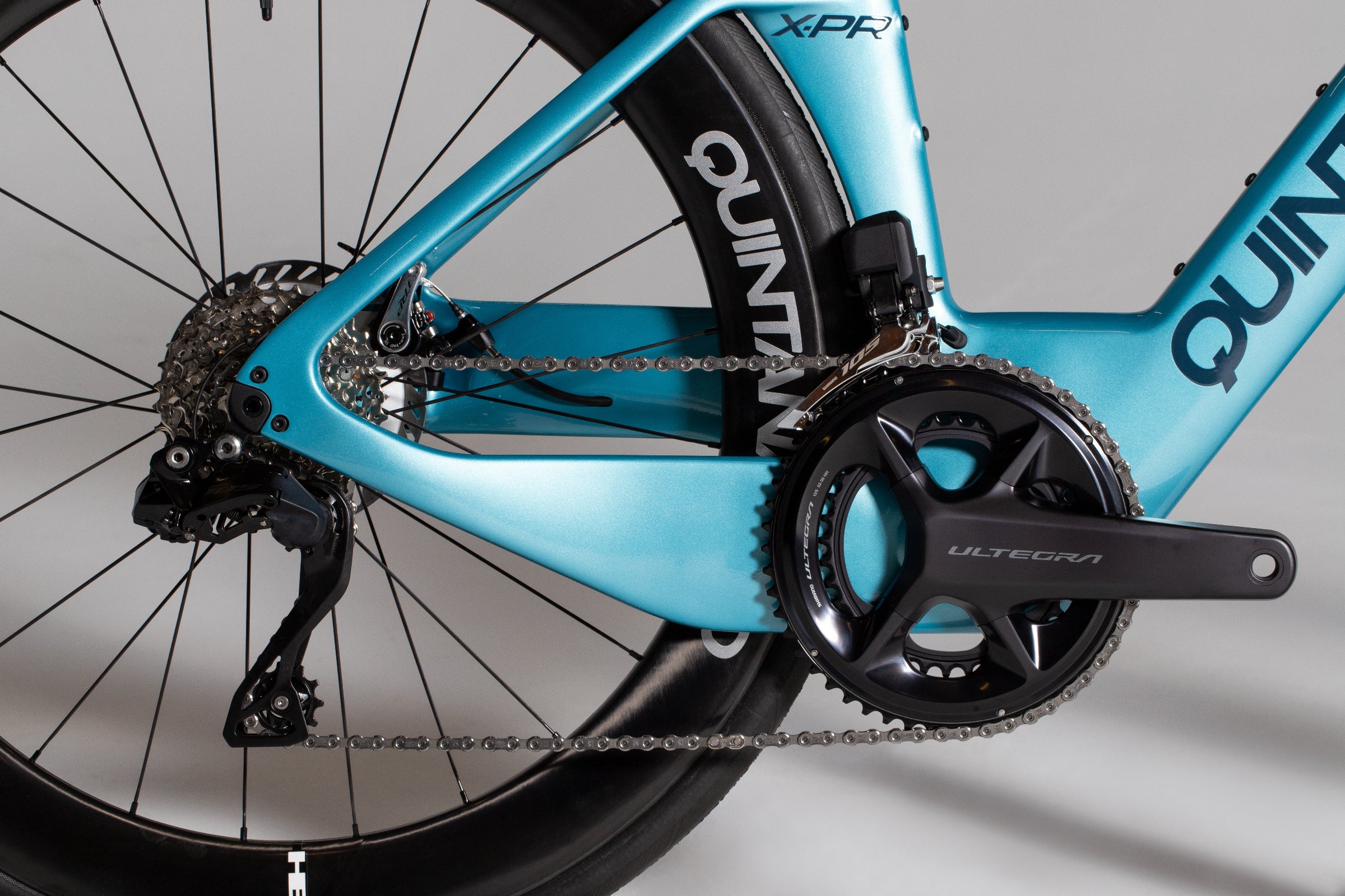 Close-up of a Caribbean Blue Pearl X-PR bicycle with branding on a gray background. For All.