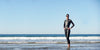 Woman standing on beach in HYDROsix2 wetsuit